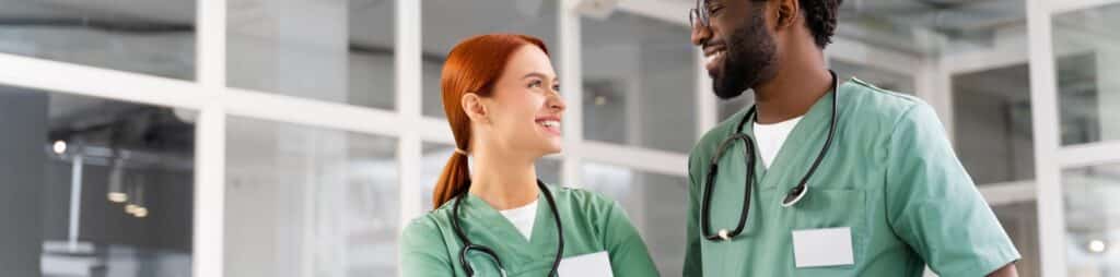 Two healthcare workers dressed in scrubs.