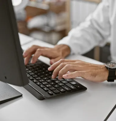 Healthcare professional typing on a keyboard during EHR system implementation.